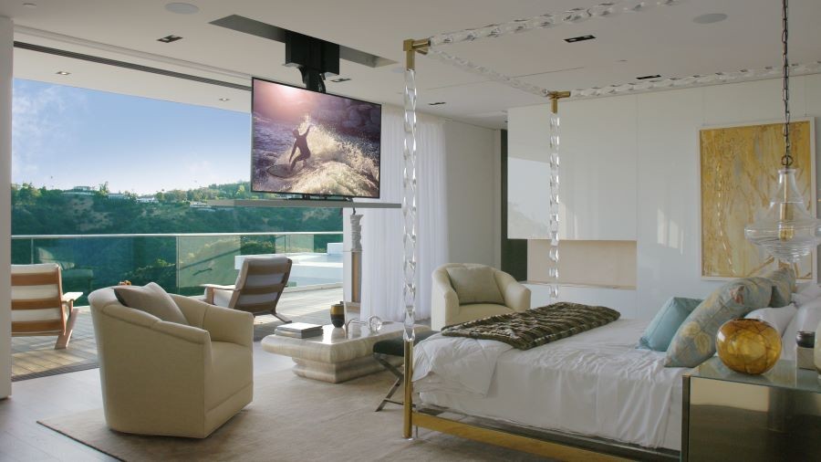 A bedroom with an in-ceiling TV and picture windows.