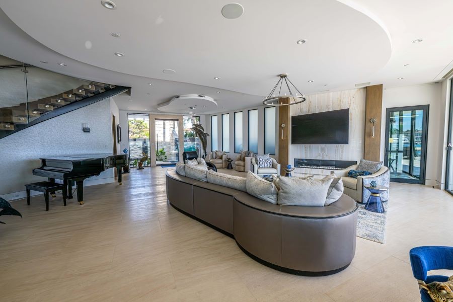 A living room with a grand piano, TV, and in-ceiling speakers.