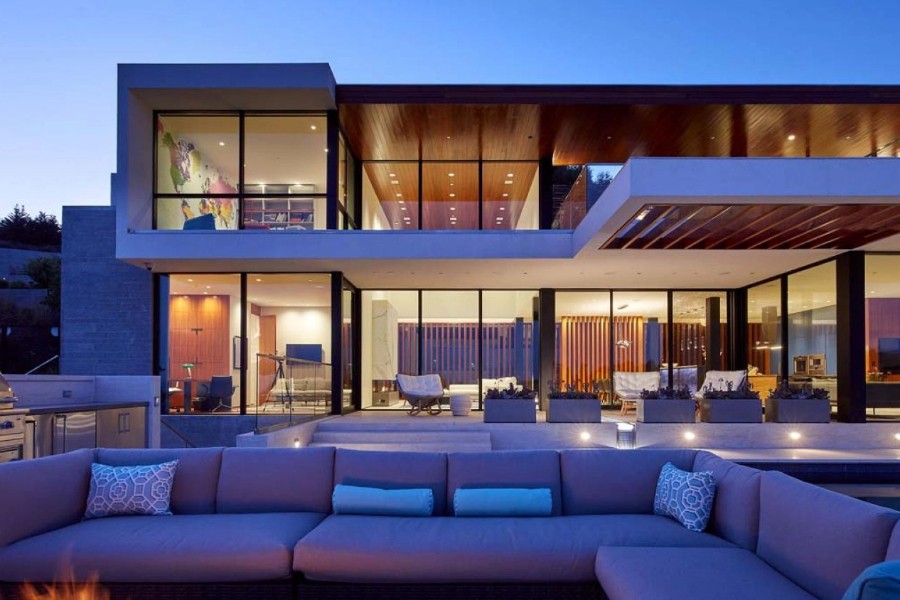 A modern house with outdoor seating area and a fire pit.